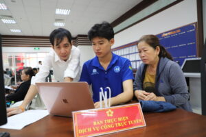 Cán bộ Trung tâm phục vụ hành chính công phường Phú Nhuận, TP HCM, hỗ trợ người dân nhập thông tin lên Cổng dịch vụ công quốc gia, ngày 23/7. Ảnh: Lê Tuyết